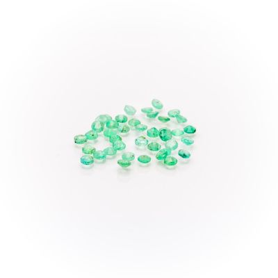 a pile of green glass beads sitting on top of a white surface