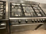 stainless steel stove top with four burners in a commercial kitchen