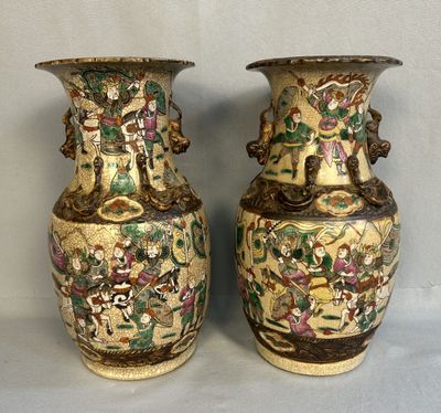 une paire de vases chinois anciens posés sur une table, sur fond gris