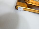 un petit miroir posé sur la table, avec une étiquette de prix accrochée dessus