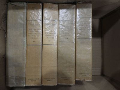 cinq livres dans une boîte, posés sur une étagère