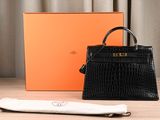 a black purse sitting on top of a wooden table next to an orange box