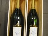 deux bouteilles de champagne dans un coffret en bois posé sur un sol carrelé