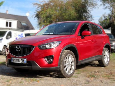 La Mazda CX-5 rouge est garée sur le bord de la route.