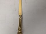 a gold plate with a knife and fork on it