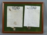 an old letter and a piece of paper on display in a wooden frame