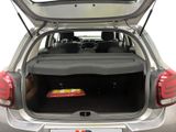 the back of a silver car with its trunk open and a tray of food in the trunk