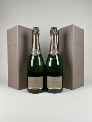 deux bouteilles de champagne posées l'une à côté de l'autre devant une boîte
