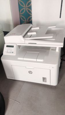 a printer sitting on top of a desk next to a chair