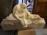 une statue représentant un homme et une femme assis sur un rocher