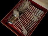 silverware in a case with red velvet lining on a black background