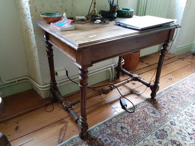 une table en bois sur laquelle est posé un ordinateur portable