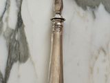 a silver spoon with a silver handle on a marble table