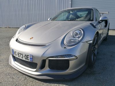 une voiture de sport argentée garée devant un immeuble