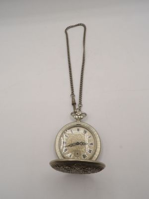 a close up of a pocket watch on a chain on a white surface