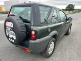 une voiture verte avec un cache-pneu à l'arrière