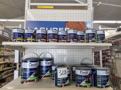 de nombreux pots de peinture sur une étagère dans un magasin