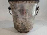 un vase en argent posé sur une surface blanche