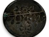 a black metal button with a flower design on it