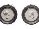 une paire de portraits, encadrés de blanc et d'or, représentant un homme et une femme
