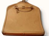 un sac beige muni d'une anse, accroché à un mur
