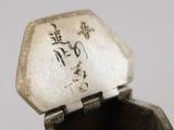 someone is holding a silver box with writing on it