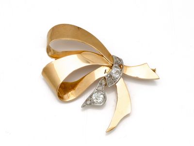 une image représentant une broche en forme de nœud, en or et diamants