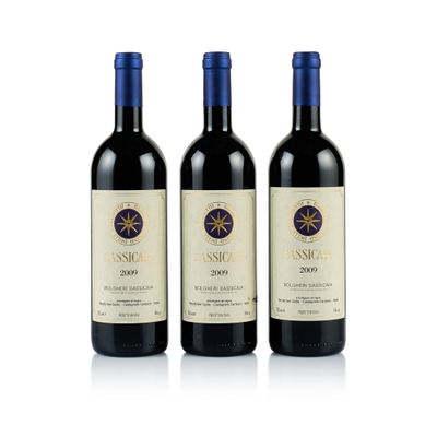 trois bouteilles de vin rouge posées l'une à côté de l'autre sur une surface blanche