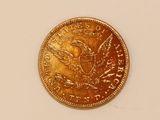 a close up of a gold coin on a white surface
