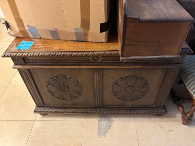 a wooden chest sitting on the floor next to a chair