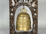 une vieille cloche en laiton dans un cadre en bois, sur fond blanc
