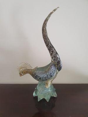une sculpture en verre représentant un oiseau posé sur une table