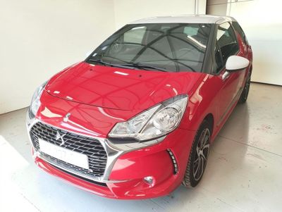La voiture rouge est garée dans le garage de l'immeuble.