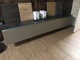 un parquet en bois massif dans un salon équipé d'un meuble TV à plateau en verre