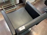 une photo d'un fauteuil en cuir noir dans un showroom