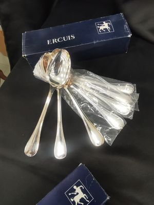 two silver spoons and a blue box on a black table
