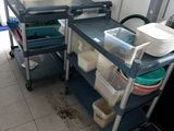 a kitchen with a sink and a cart with dishes on it