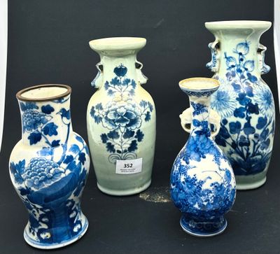 Plusieurs vases bleus et blancs sont alignés sur une surface noire