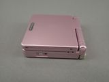 a pink electronic device sitting on a gray surface