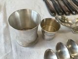 many spoons and spoon cups sitting on a table