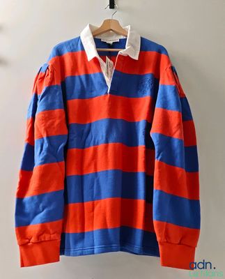 an orange and blue striped rugby shirt hanging on a wall