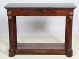 une vieille table en bois avec un plateau en marbre, posée sur un plan de travail blanc