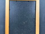an old picture frame hanging on a wall with a black background