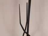 a metal sculpture of a tree with a branch on top of it