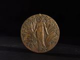 an image of a gold medal with a woman on it