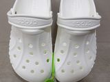 a pair of white crocs that are next to each other