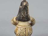 an image of a small vase with a hat on it