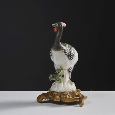 a figurine of a bird sitting on top of a tortoise