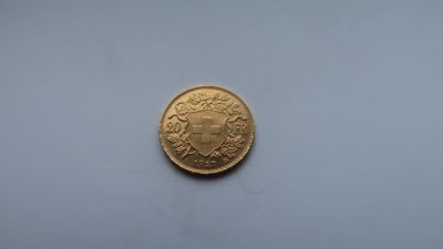 gros plan d'une pièce d'or sur une surface blanche