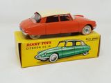 an old toy car sitting on top of a box on a white surface